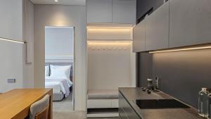 a kitchen with a sink and a bed in a room at UNIT Nuanu Village in Canggu