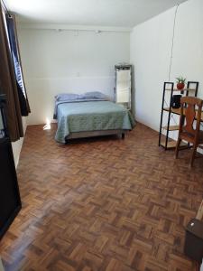 a bedroom with a bed and a wooden floor at Casa San Rafael in Oaxaca City