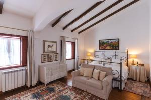 a bedroom with a bed and a couch and a chair at Charming Farm House With Pool in Ferreira do Alentejo