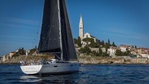 a sailboat on the water with a city in the background at Z6 Dolcevita Signature - Villa & Private Yacht in the Heart of Rovinj in Rovinj