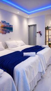 Apartamento Inteligente - 50m da praia في جاباراتينغا: ثلاثة أسرّة في غرفة ذات سقف أزرق