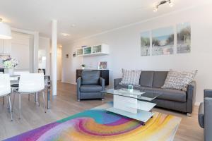 a living room with a couch and a table at Strandlächeln in Neue Tiefe Fehmarn