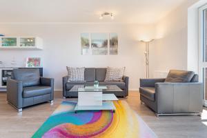 a living room with two couches and a colorful rug at Strandlächeln in Neue Tiefe Fehmarn +25 photos