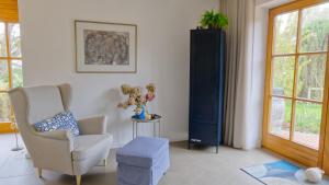 a living room with a chair and a plant at Ferienhaus Mind-Storm in Rimsting