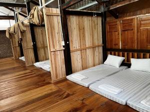 two beds in a room with wooden floors at Rocky Eco House in Na Hang