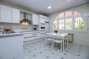 a white kitchen with a table and a window at Spacious Private Villa with Pool in Salou in Salou