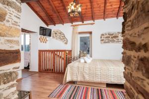 a bedroom with a bed and a tv on a wall at Mulberry Cottage in Samos