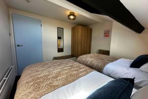 a hotel room with two beds and a door at The Joseph Cosy at Lancaster in Lancaster
