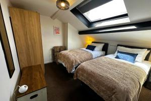 a hotel room with two beds and a skylight at The Joseph Cosy at Lancaster in Lancaster