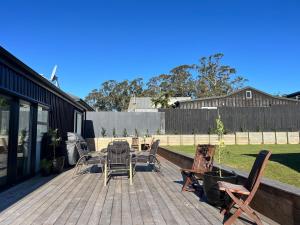 a deck with chairs and a table and a table and chairs at The Batch in Oamaru