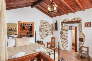 a bedroom with a bed and a stone wall at Mulberry Cottage in Samos