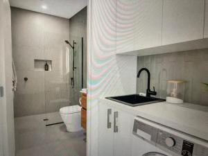 a kitchen with a sink and a toilet in a bathroom at The Batch in Oamaru +15 photos