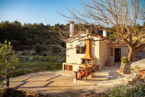 a small house with a bench in front of it at Mulberry Cottage in Samos