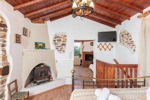 a living room with a fireplace and a tv at Mulberry Cottage in Samos