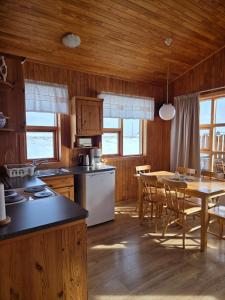 a kitchen and dining room with a table and chairs at Ekra Cottages in Lagarfljótsvirkjun