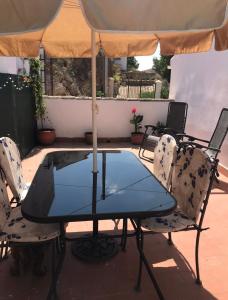 a table and chairs with an umbrella on a patio at Casa Tomas in Albox