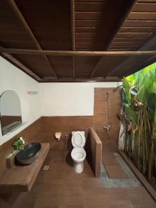 a bathroom with a toilet and a bath tub at KRECOG Bungalow in Sampalan