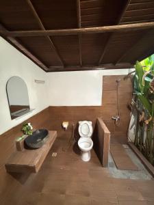 a bathroom with a toilet and a bath tub at KRECOG Bungalow in Sampalan