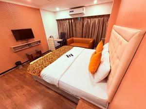 a bedroom with a large bed and a television at Hotel Highway Inn Andheri East in Mumbai