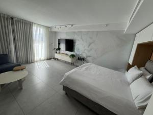a bedroom with a bed and a tv in it at Sweet Sea Side Eilat - סוויט סי סייד, אילת in Eilat +68 photos