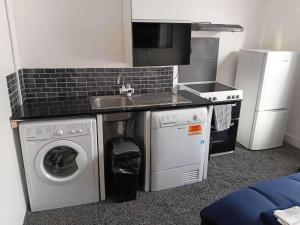 a small kitchen with a sink and a washing machine at Sleeps 2 - Parking - Wifi in Oldbury +2 photos