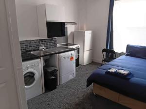 a bedroom with a bed and a sink and a washing machine at Sleeps 2 - Parking - Wifi in Oldbury
