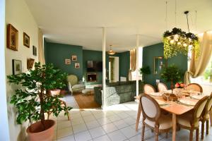 a dining room with a table and chairs and a living room at Château de Ravenel in Ravenel