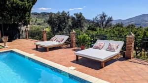 a patio with two chairs next to a swimming pool at La Cañota King Rooms Adults Only in Talara