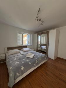 a bedroom with a large bed and two windows at Central nude oasis in Makarska