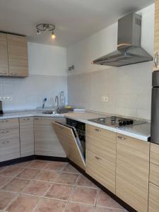 a kitchen with wooden cabinets and stainless steel appliances at Central nude oasis in Makarska +12 photos