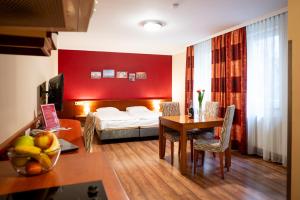 a hotel room with a bed and a table and a room at City Home Budapest in Budapest