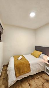 a bedroom with a bed with a yellow blanket on it at 2 Hermanas in Cudillero