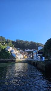 a river with a town in the background at 2 Hermanas in Cudillero