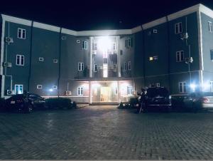 a large building at night with people standing outside at Davic-lite hotel and suites in Okitipupa +7 photos