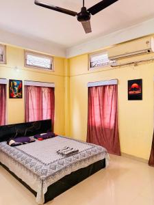 a bedroom with a bed with red curtains at Moon Villa Homestay in Nowgong