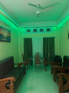 a living room with a couch and a table and chairs at Moon Villa Homestay in Nowgong