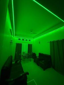 a green room with a couch and chairs in it at Moon Villa Homestay in Nowgong +13 photos