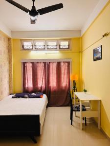 a bedroom with a bed and a table and a window at Moon Villa Homestay in Nowgong
