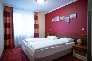 a bedroom with two beds and a red wall at City Home Budapest in Budapest +161 photos