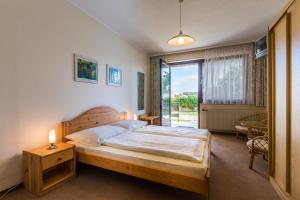 a bedroom with a large bed and a large window at Haus Helene in Mörbisch am See