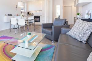 a living room with a couch and a table at Strandlächeln in Neue Tiefe Fehmarn