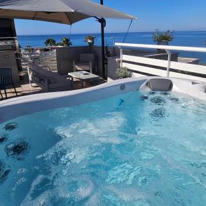 a large swimming pool with the ocean in the background at B&B Naiadi Anzio in Anzio