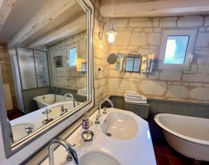 a bathroom with a large mirror and a tub and a sink at La Motelle N 5 in Les Ulmes
