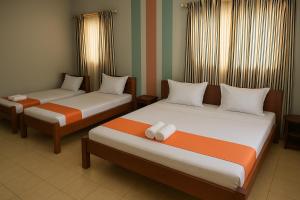 two beds in a hotel room with at L'Hotel 5-5 in Mahajanga