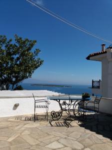a table and chairs with a view of the ocean at Maria Apostolou villa in Almiros