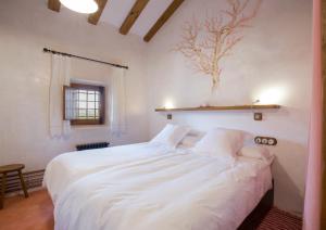 a bedroom with a large bed with white sheets at Casa del Labrador in Jumilla