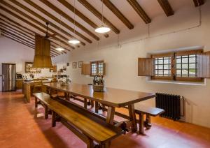 a dining room with a large wooden table and benches at Casa del Labrador in Jumilla