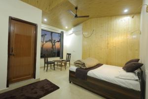 a bedroom with a bed and a table and chairs at Ransuli mountain retreat in Dehradun +87 photos