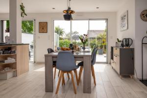 a kitchen with a wooden table and chairs at Chambre d'hôtes reflets du Golfe in Arradon