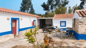 a house with blue and white walls and a patio at Casa no Campo in Porto Covo